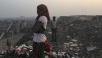 Kvinne står på søppelplassen Okhla landfill i Delhi, hvor restsøppel dumpes