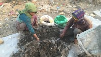 Kvinne og mann leter etter metall blant restavfall på Okhla landfill i Delhi