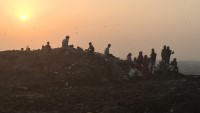 Voksne og barn leter etter metall i resteavfallet på Okhla landfill i Delhi