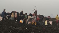 Voksne og barn leter etter metall i restavfallet på Okhla landfill i Delhi