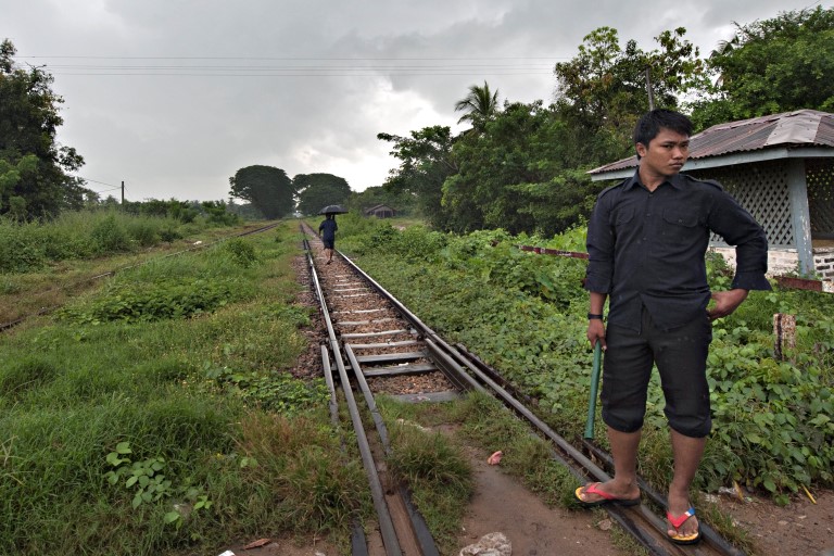 Mann går langs jernbanelinje i Myanmar