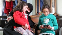 Grandmother En'am Ghannam with granddaughters play the EduApp4Syria game Feed the Monster