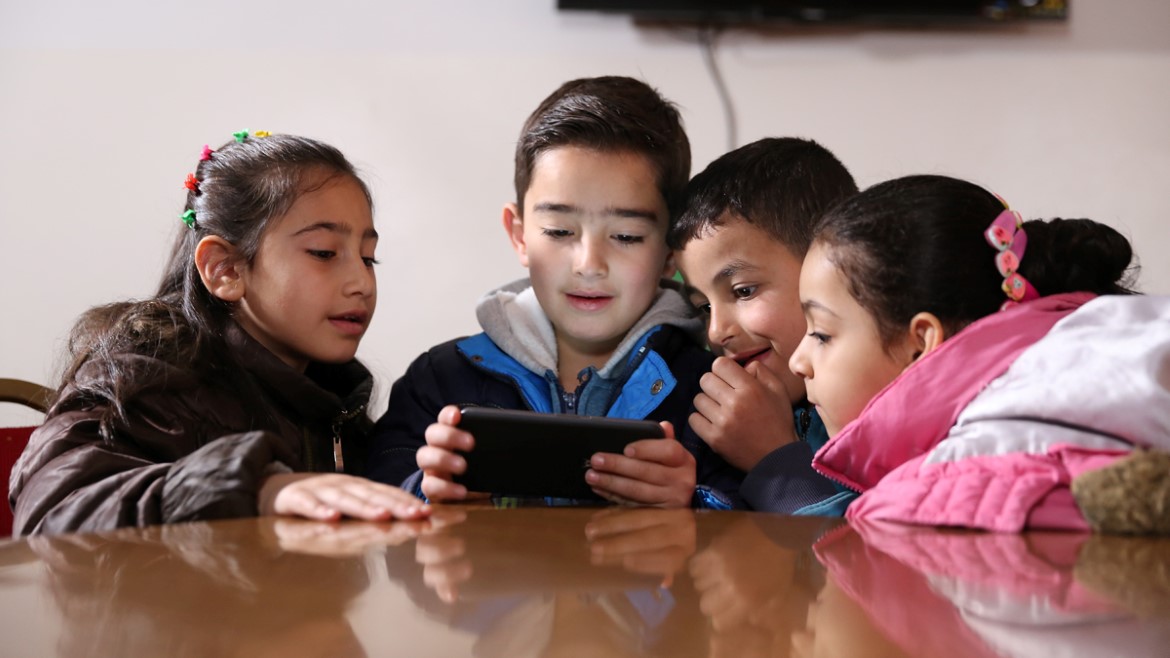 Group of Syrian children living in play the EduApp4Syria game Antura