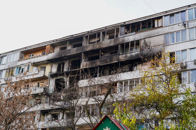 En boligblokk med omfattende brannskader, svarte fasader og knuste vinduer.