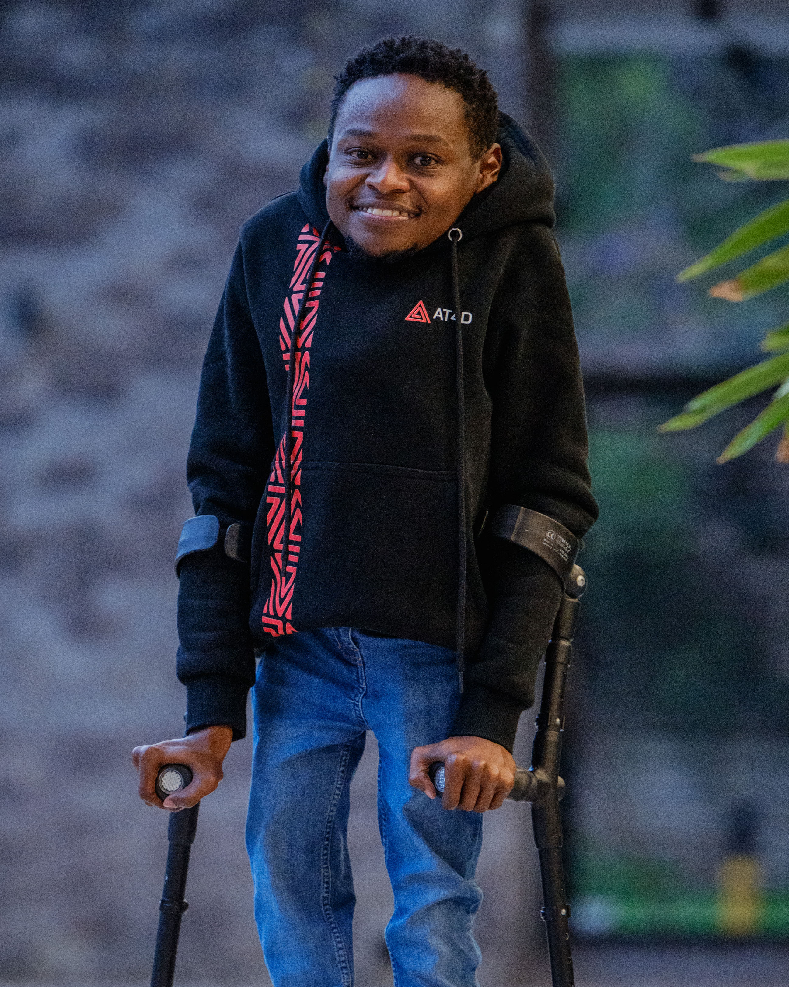 Man with crutches is smiling to the camera. 