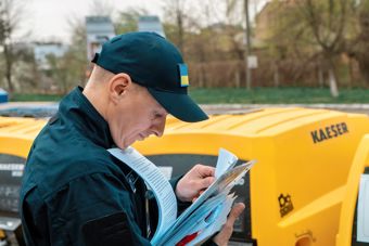 Mann med grønn caps holder et skjema