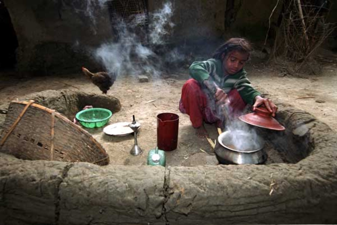 Jente lager mat i et utekjøkken, Bangladesh