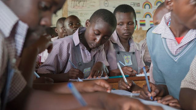 Students sitting with desks in a classroom studying